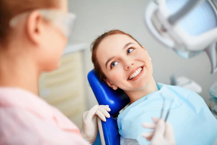 ילדה מחייכת אצל רופא שיניים לילדים